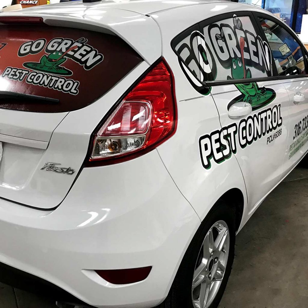 Go Green Pest Control's Company Car - Photo of the exterior of white Ford Fiesta taken from the passenger rear. The car is branded in the back and sides with Go Green Pest Control's logo and contact information.